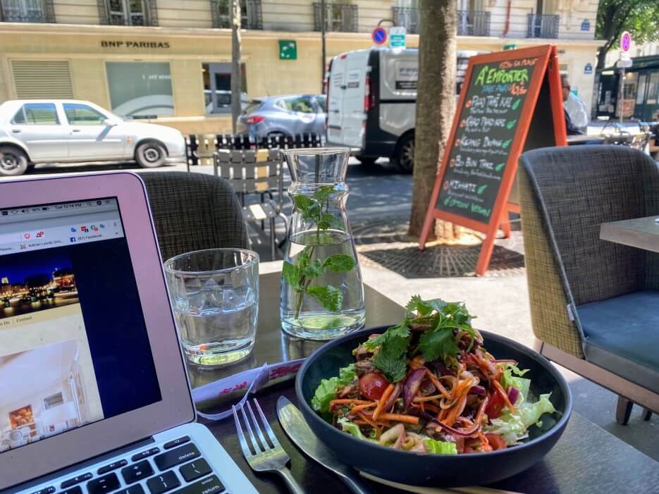 Adrian Leeds on her laptop at a café on rue de Bretagne in Paris