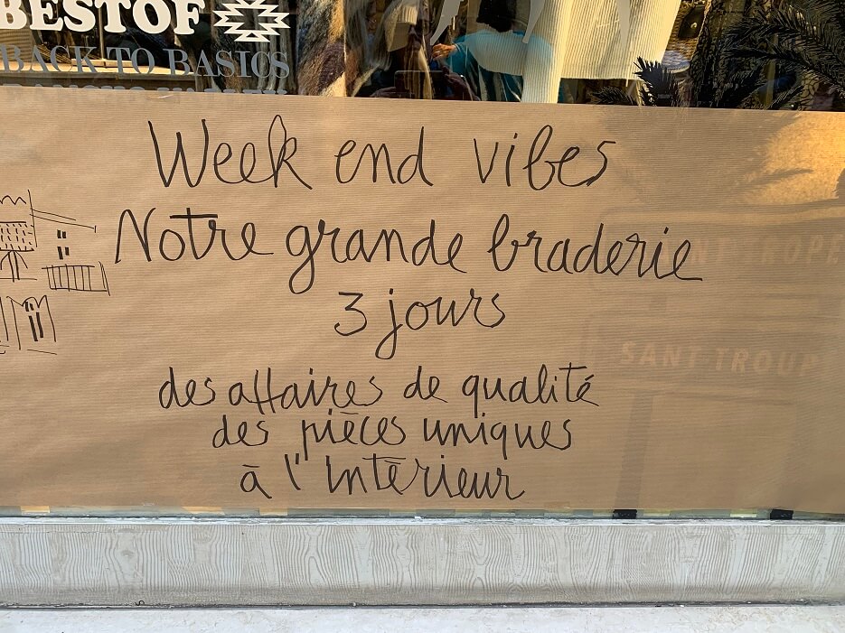 Handwritten sign in a shop window annoucing the Grande Braderie in Saint-Tropez