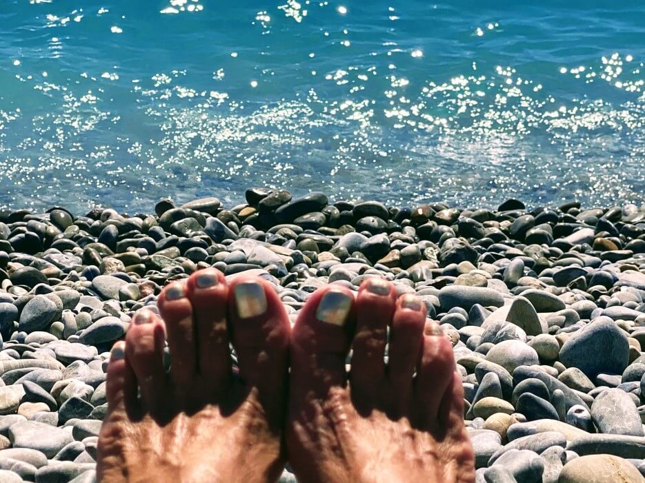 Adrian Leeds' toes on the beach in Nice, the sea in the background