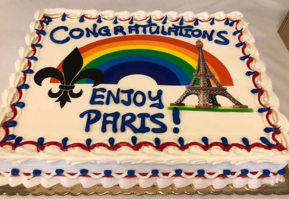 Cake decorated with a fleur de lis and an Eiffel Tower saying Congratulations, Enjoy Paris