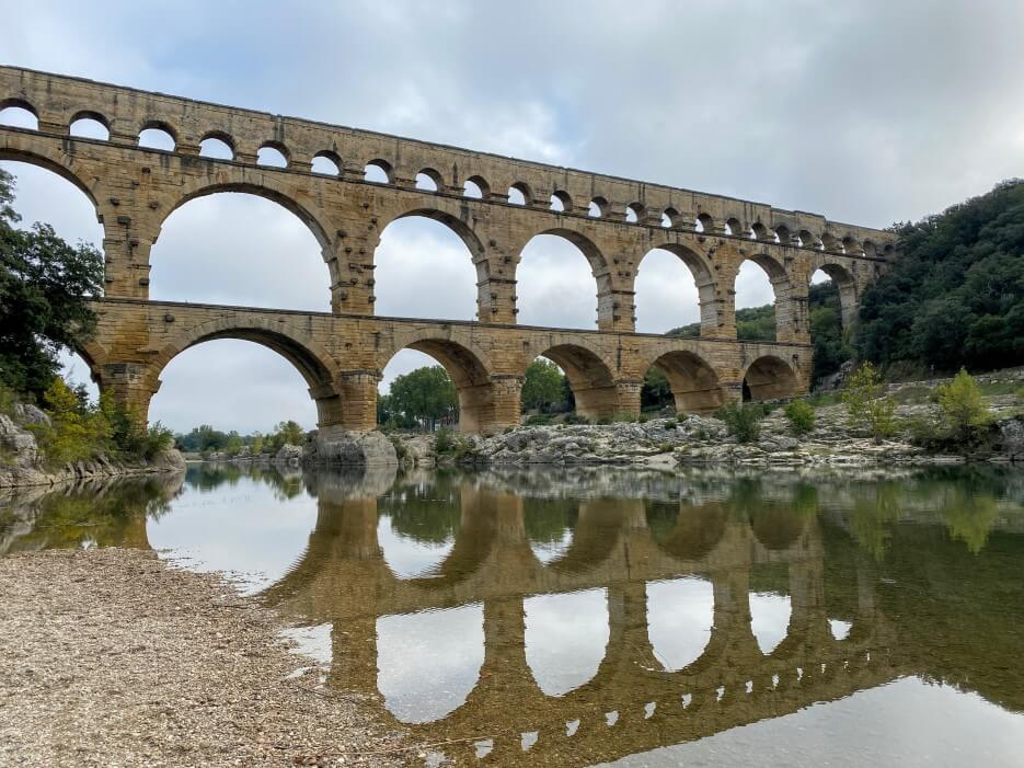Le Pont du Gard reflected in the river below