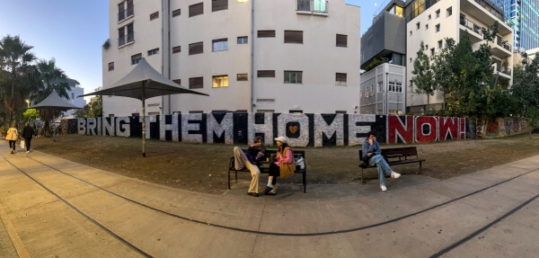 Bring Them Home in big letters on a fence around a building