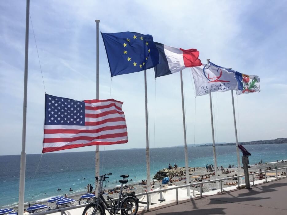 Flags of the US, EU, and France flying in Nice, France