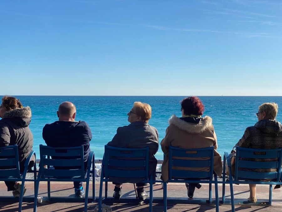 Group of people sitting by the sea in Nice, France