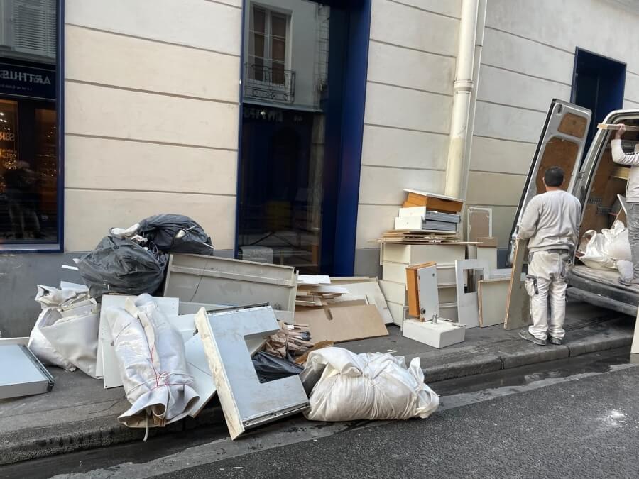 The destroyed remnants of the desk from Adrian Leeds' apartment in Paris on the sidewalk outside the building