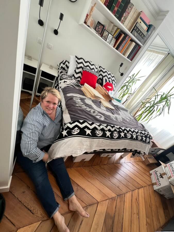 Diane moving boxes out from under the bed in Adrian Leeds' apartment in Paris