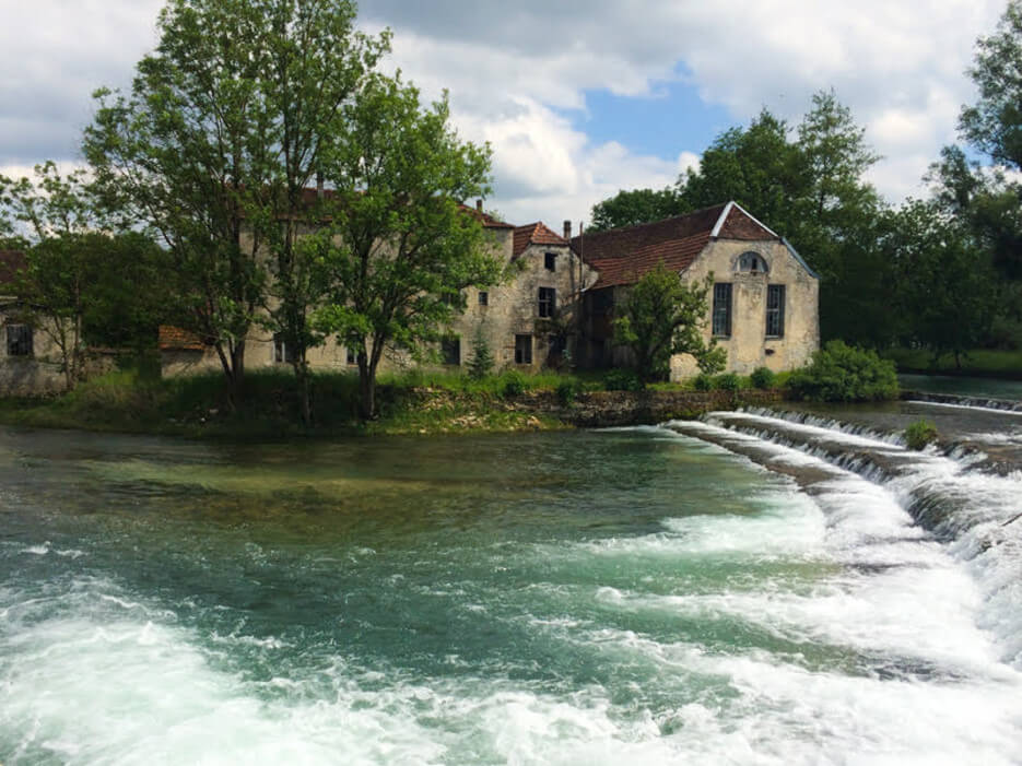 A charming French country house with a river rushing by it