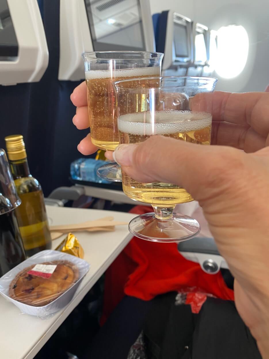 Photo of Adrian Leeds enjoying champagne and wine on her Air France flight to the United States