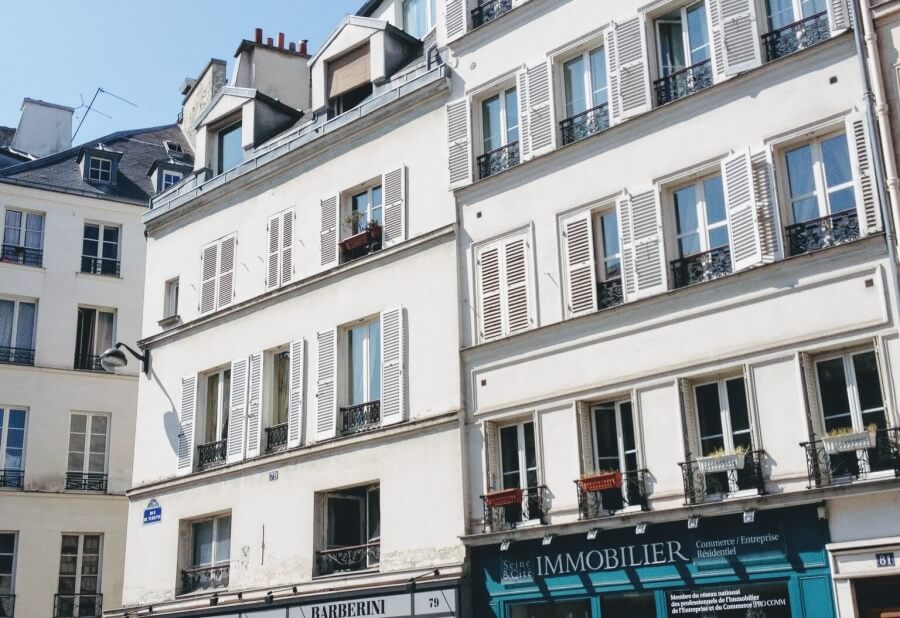 Typical Parisian apartment building with a real estate office on the ground floor