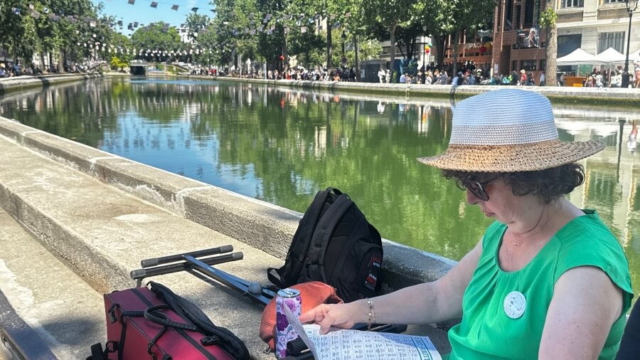 A woman reviewing the program of Voix sur Berges on the Canal Saint-Martin in Paris