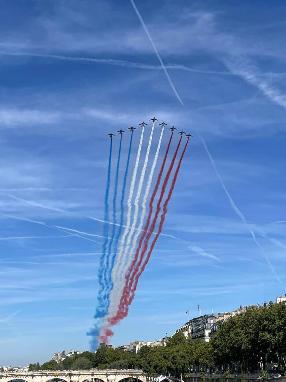 Aircraft trailing blue white and red smoke over Paris for Bastille Day