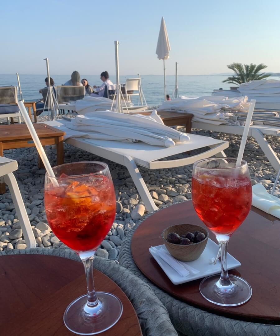 Two aperol spritzes on the beach