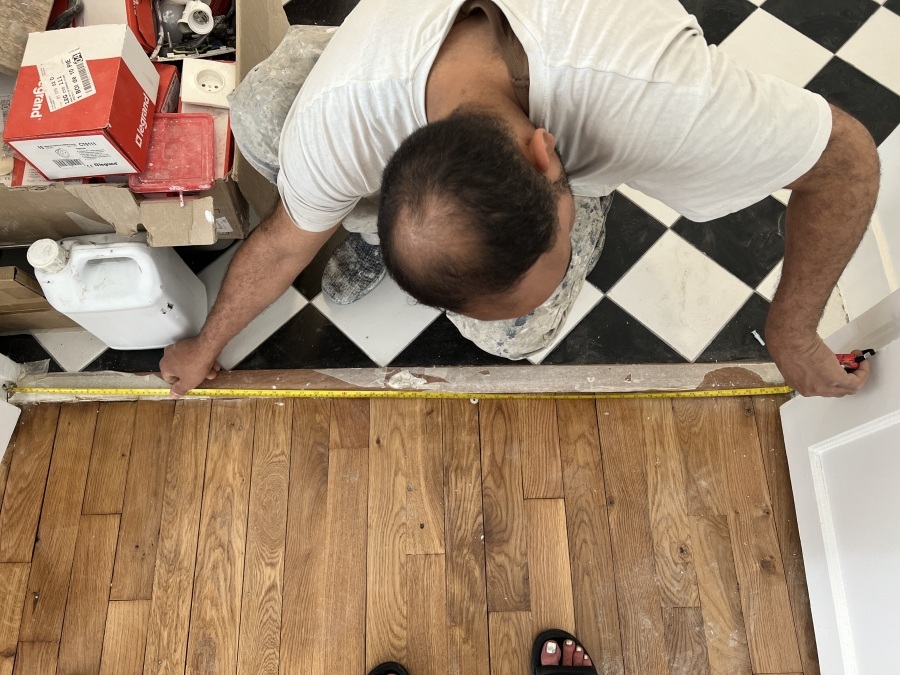 Worker measuring to make sure things could fit through the bathroom door