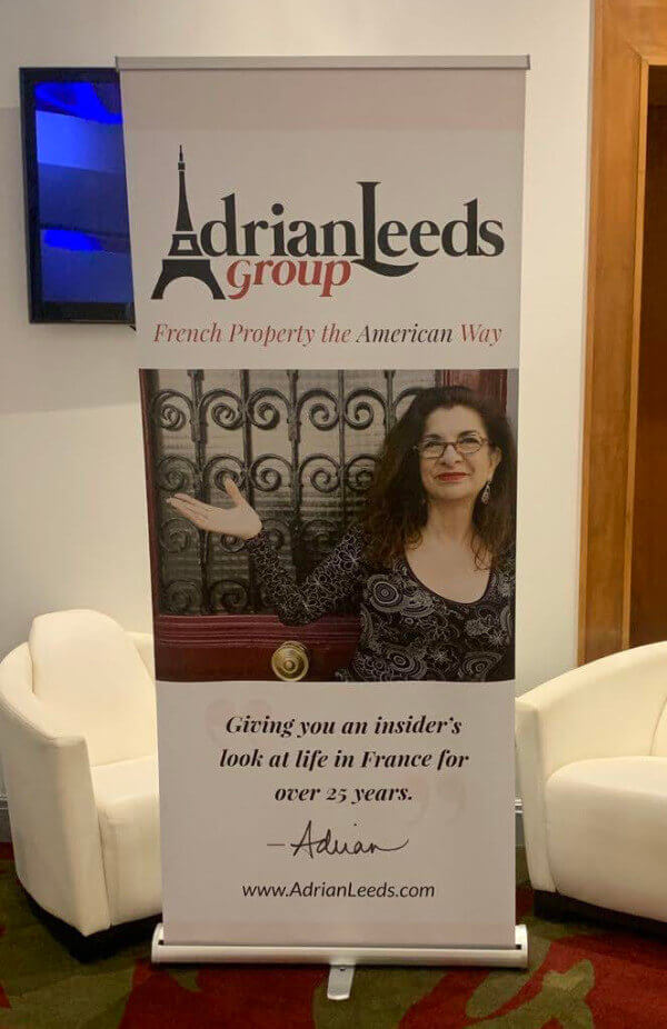 Standing banner with a photo of Adrian for the entrance to the room for the Living and Investing in France conference in Nice