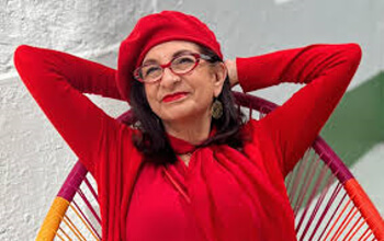 Adrian Leed in a red top with one of her signature red berets