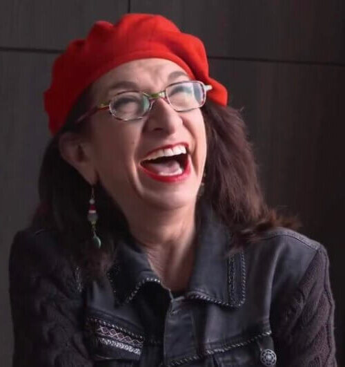 Adrian Leeds wearing a signature beret and laughing
