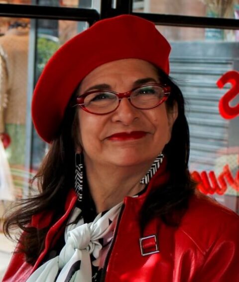 Adrian Leeds in a red leather jacket and red beret