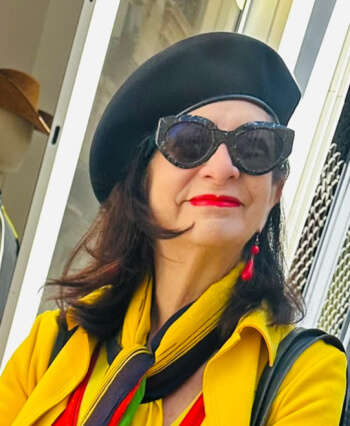Adrian Leeds dressed in yellow wearing a signature black beret