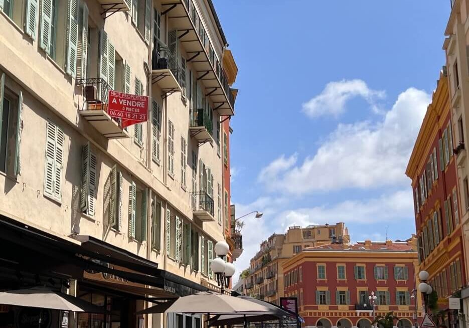 View of apartment building in Nice with a for sale sign on one of the balconies
