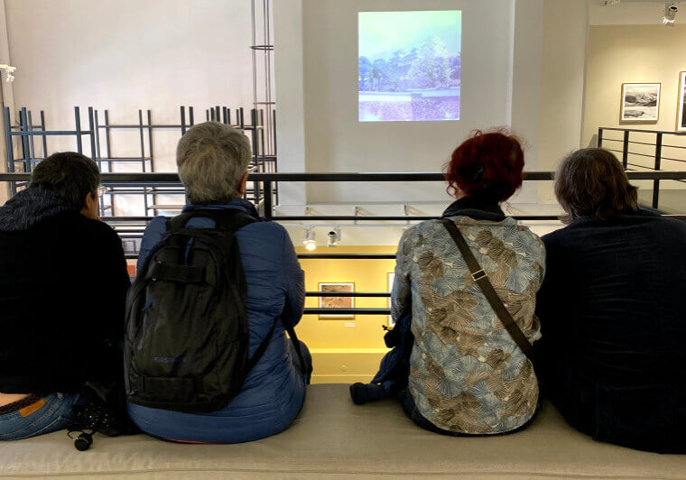 Four people in a museum watching a video