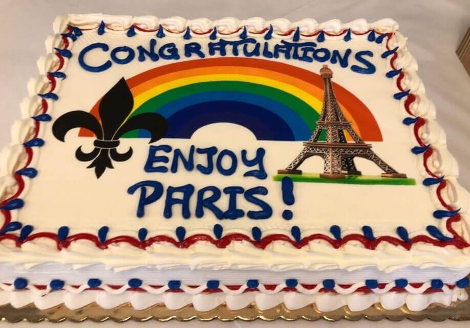 Cake decorated with a fleur de lis and an Eiffel Tower saying Congratulations, Enjoy Paris