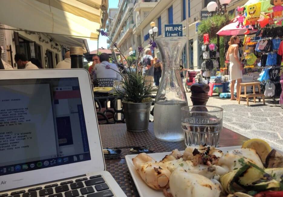 Partial view of a laptop set up at a café table during lunch