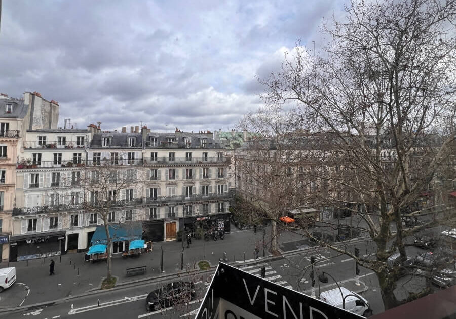Apartment buildings in Paris, France with a for sale signs