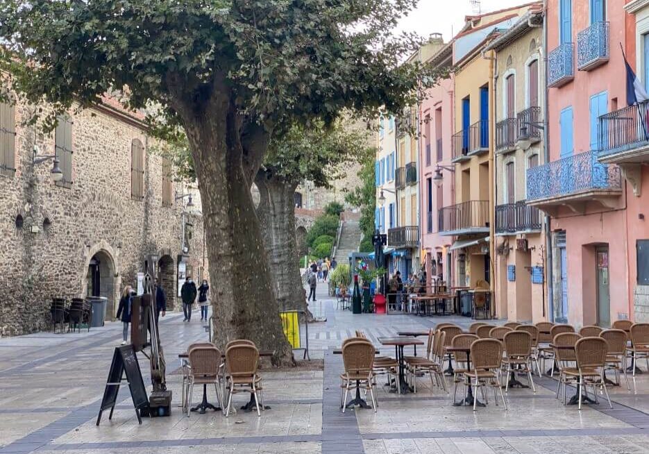 A quiet street in France showing off the colorful buildings and their balconies