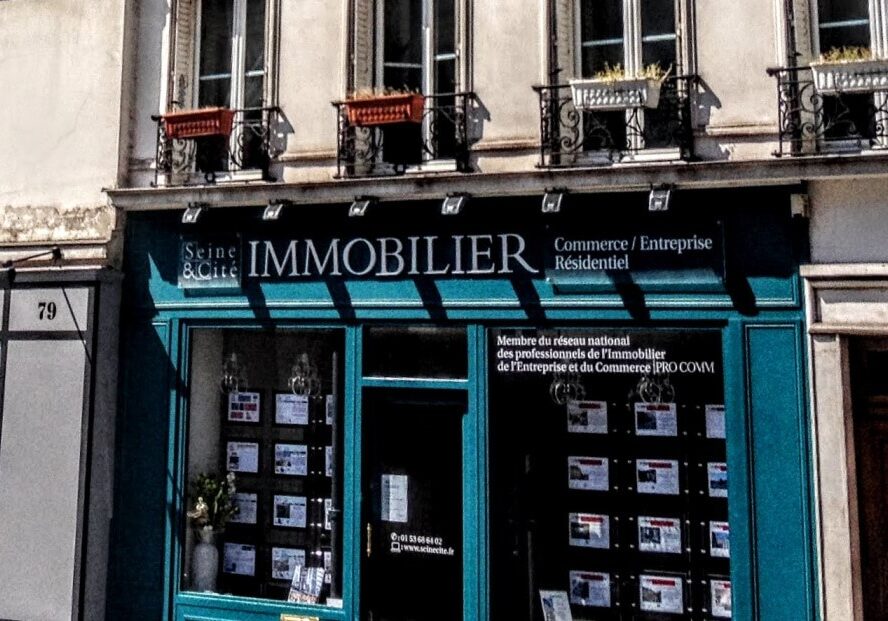 Facade for a real estate office in Paris with photos of properties in the window
