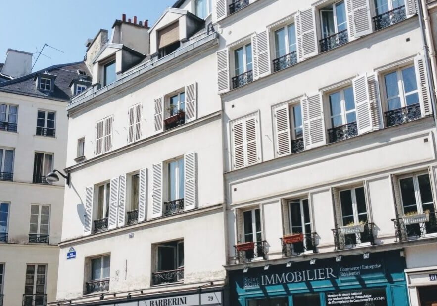 Typical Parisian apartment building with a real estate office on the ground floor