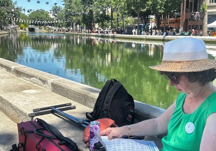 A woman reviewing the program of Voix sur Berges on the Canal Saint-Martin in Paris