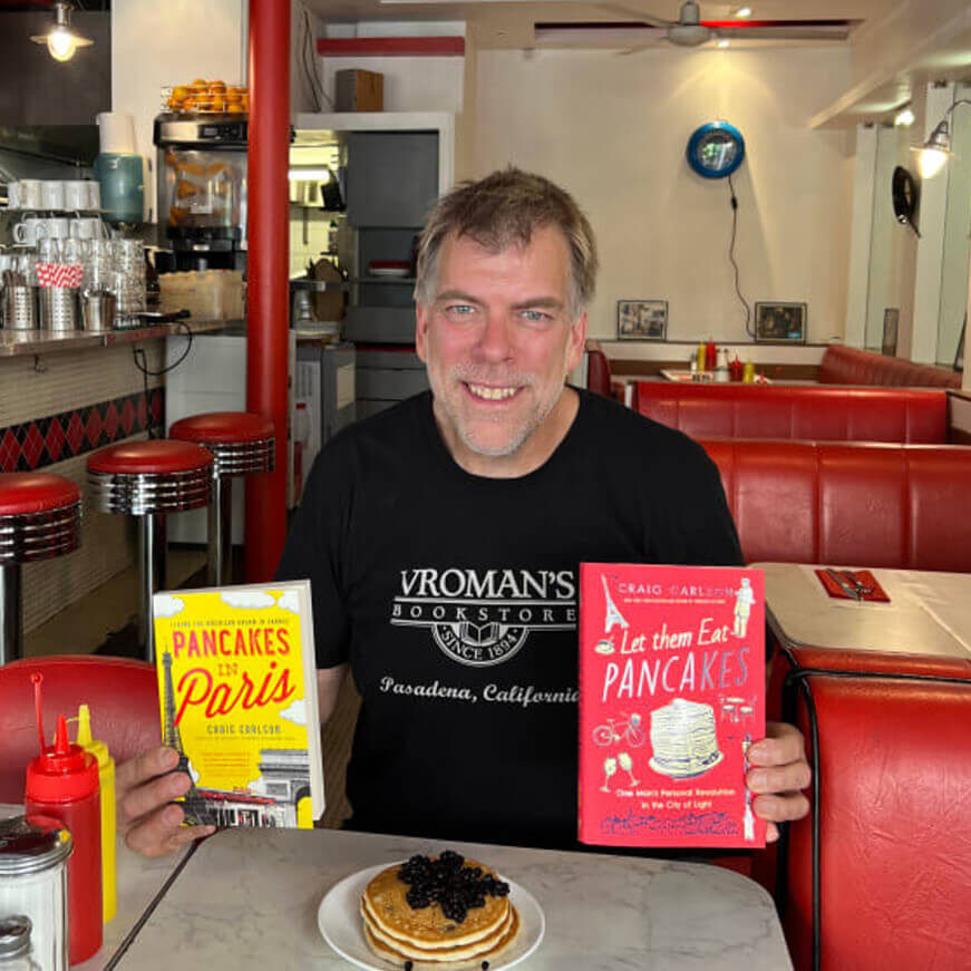 Craig Carlson with his two books, Breakfast in America and Let Them Eat Pancakes