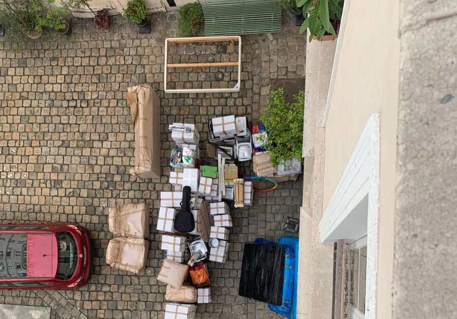 Stacks of moving boxes and furniture in the courtyard of Adrian Leeds' apartment building in Paris