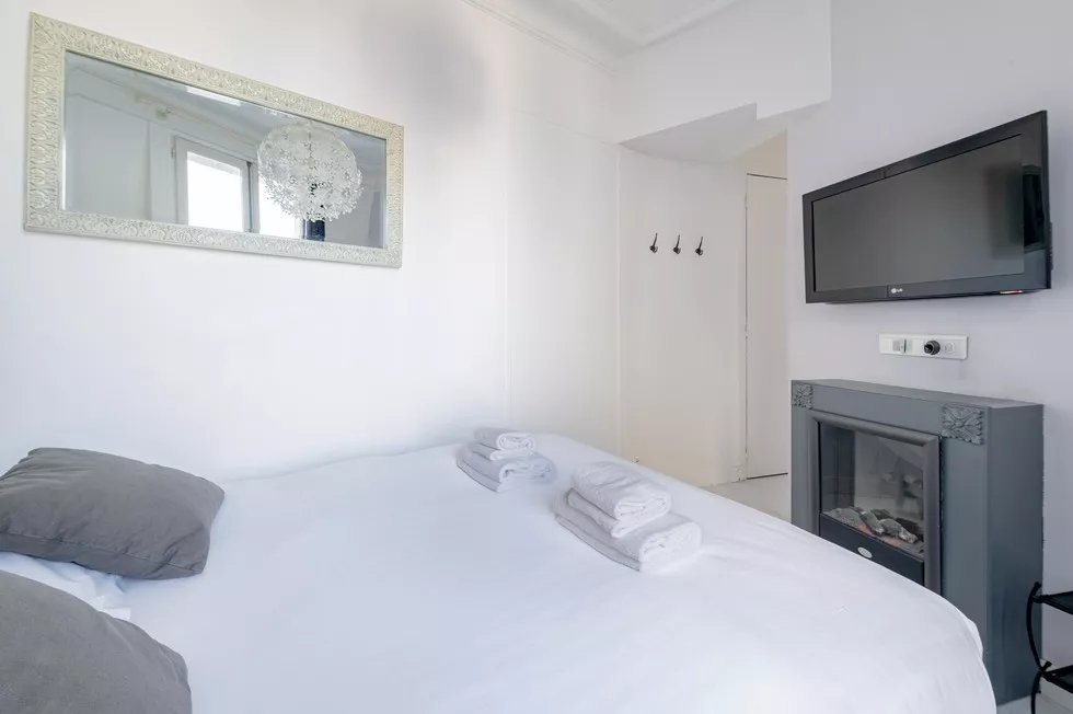 Bright bedroom with fireplace and tv and large window at 9 rue Lagrange Paris 75005