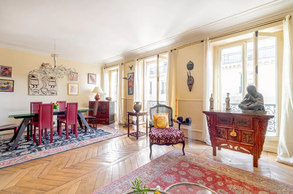 Rue de Palestro - dining and living with multiple floor to ceiling windows and original hardwood floors Large apartment in central Paris France