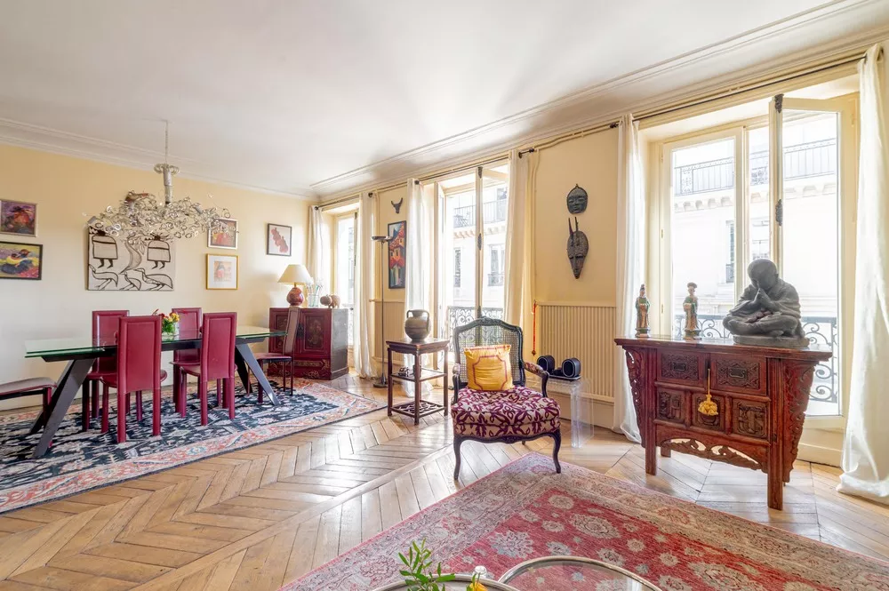 Rue de Palestro - dining and living with multiple floor to ceiling windows and original hardwood floors Large apartment in central Paris France
